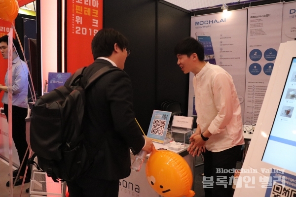 23일 서울 동대문디자인플라자(DDP)에서 열린 '코리아 핀테크 위크 2019'에서 페르소나시스템 관계자가 자사 서비스를 설명하고 있다.[사진=블록체인밸리]