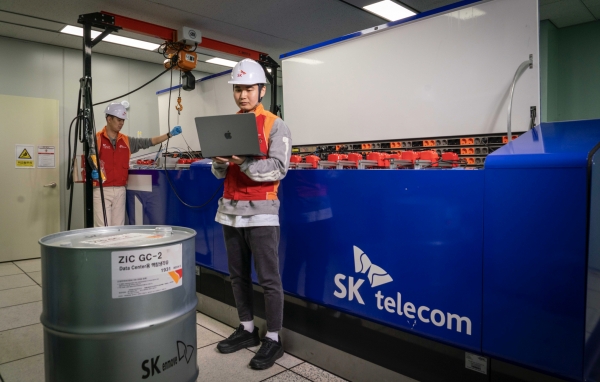 SKT는 차세대 열관리 방식인 ‘액침냉각’ 기술 검증에 성공했다고 밝혔다. 사진은 SKT 직원들이 인천사옥에 설치된 액침냉각 테스트 장비를 점검하는 모습 (사진=SKT)