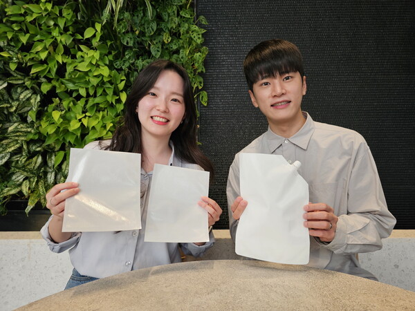 SK지오센트릭 구성원들이 SK지오센트릭의 단일 플라스틱 소재로 율촌화학이 제조한 포장재 시제품을 소개하고 있다.