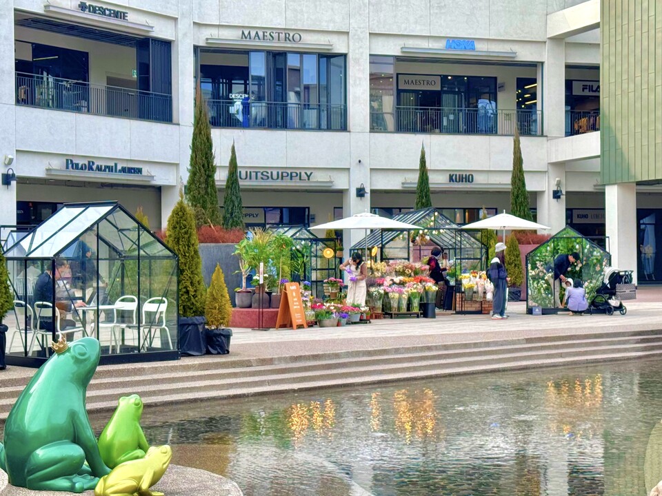 현대프리미엄아울렛 김포점의 분수광장 주변이 유리온실을 봄꽃으로 채워 만든 '플라워 빌리지'로 꾸며져 있다. [현대백화점 제공]