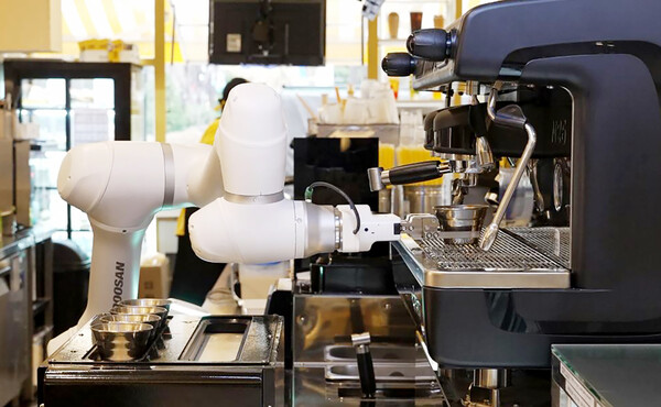 두산로보틱스 협동로봇이 추출된 에스프레소가 담긴 샷 잔을 집고 있다.