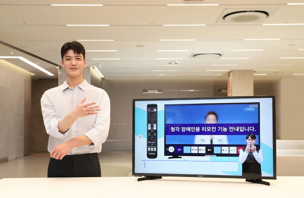 삼성전자 모델이 삼성스토어 대치점에서 '40형 풀HD 스마트 TV'를 소개하며 '간편하다'는 수어 동작을 하고 있다.
