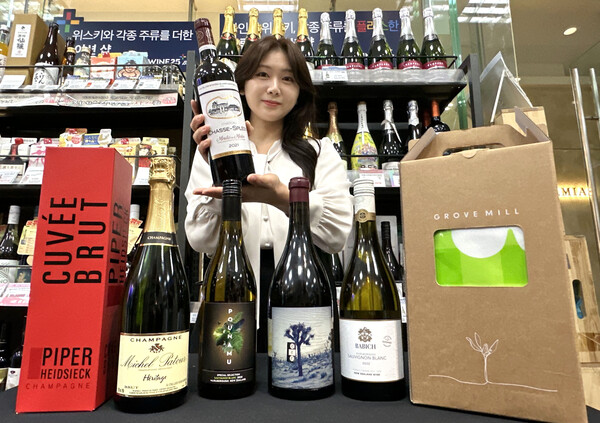 GS25에서 모델이 5월 와인행사 상품(샤토 샤스 스플린)을 들고 포즈를 취하고 있다.