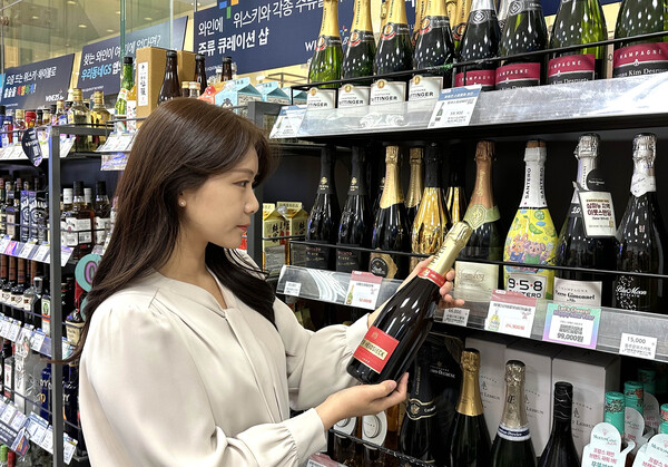 GS25에서 모델이 5월 와인행사 상품(파이퍼 하이직 뀌베 브뤼)을 들고 포즈를 취하고 있다.