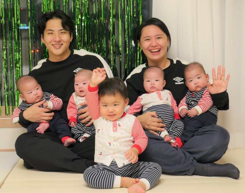 포스코 김환 대리와 박두레씨 부부가 자녀들과 웃고 있다. 맨 앞이 첫째 김우리이고 네 쌍둥이인 김무열, 김문별, 김휘, 김겸(둘째줄 왼쪽부터)이 아빠, 엄마 품에 안겨 있다. [김환 부부 제공]