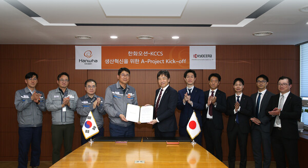 한화오션 조선소장 이길섭 부사장(왼쪽에서 네번째)이 교세라社의 마츠나가 카즈히로 사업부장(왼쪽에서 다섯번째)과 계약서에 서명하고 기념 촬영하는 모습.