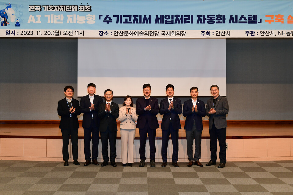지난해 11월 안산문화예술의전당에서 개최된 'AI 수기고지서 세입처리 자동화시스템' 구축 기념 행사에서 이민근 안산시장(오른쪽에서 네번째), 금동명 농협은행 부행장(오른쪽에서 세번째) 및 임직원들이 기념촬영을 하고 있다. [NH농협은행 제공]