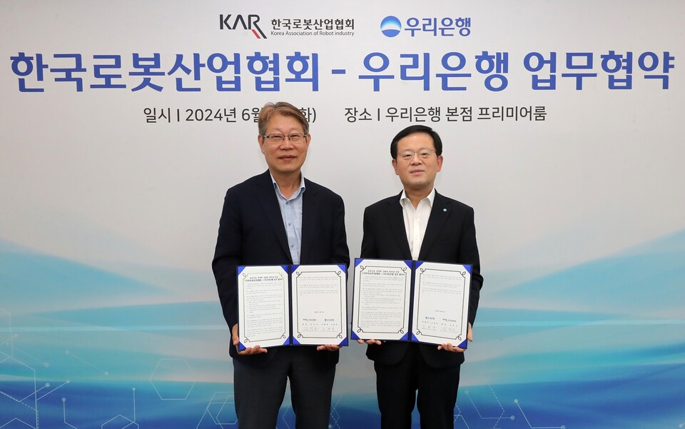 우리은행(은행장 조병규)은 지난 4일 우리은행 본점에서 한국로봇산업협회와 업무협약을 체결했다. 우리은행 조병규 은행장(오른쪽)과 한국로봇산업협회 김진오 회장이 기념촬영을 하고 있다. [우리은행 제공]