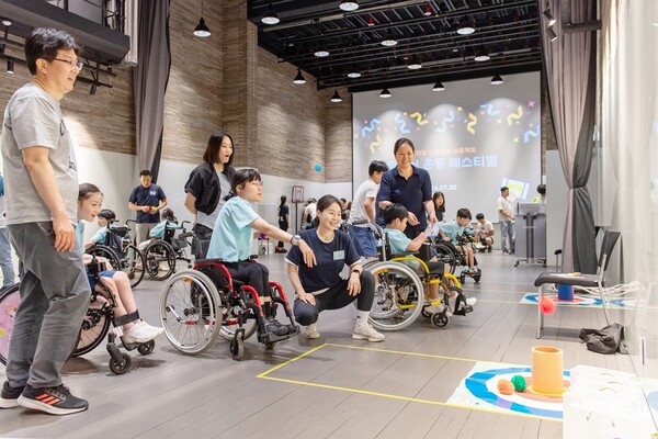 지난 20일 서울 용산 행복나눔재단 열림홀에서 진행한 ‘휠체어 사용 아동·청소년 신체발달 프로젝트 상반기 종결 페스티벌’에서 휠체어 사용 아동이 전문 트레이너와 함께 휠체어 운동에 참여하고 있다. [상상인그룹 제공]