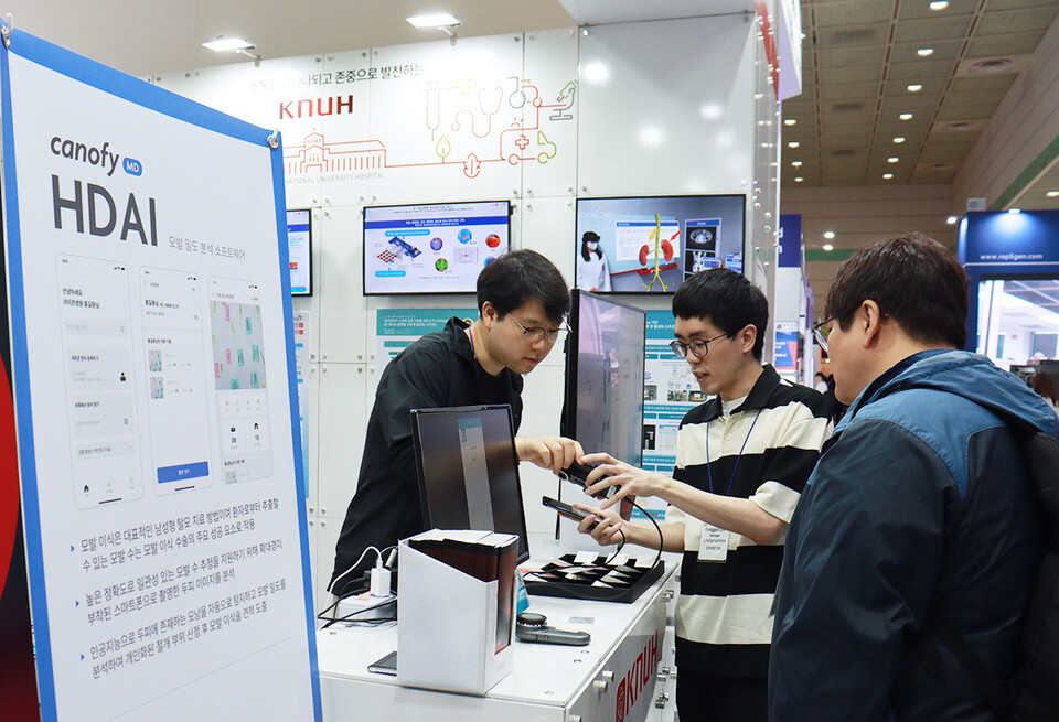 10일, 서울 코엑스에서 열린 ‘바이오코리아 2024’에서 라이프시맨틱스 관계자가 관람객들에게 모발밀도 분석 AI인 ‘캐노피엠디 HDAI’를 시연하고 있다. [라이프시맨틱스 제공]