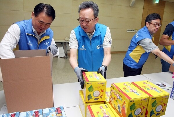 정상혁 신한은행장(가운데)이 이희수 신한저축은행 사장(왼쪽), 김지욱 신한리츠운용 대표(오론쪽)가 지난달 31일 신한은행 본점에서 진행한 ‘취약계층 아동 여가지원 KIT 제작 봉사활동’에 동참해 학습놀이 키트를 제작하고 있다. [신한은행 제공] 
