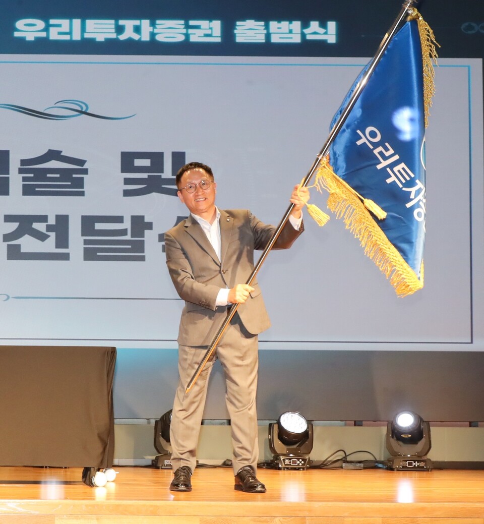 남기천 우리투자증권 대표가 회사기를 흔들고 있다. [우리투자증권 제공]