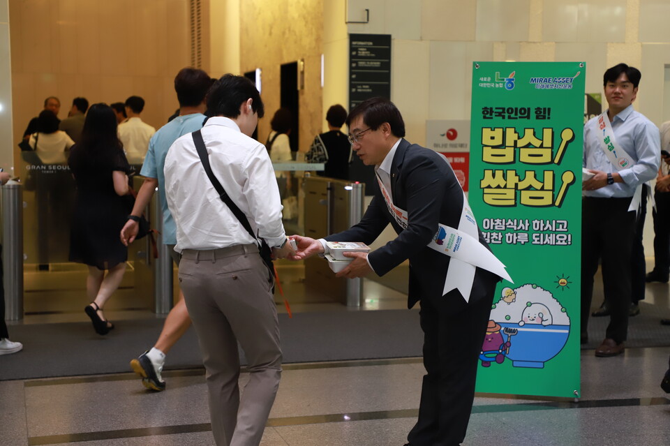 14일 서울시 종로구 그랑서울에서 박정균 농협 상호금융자산운용본부장이 출근하는 시민에게 우리쌀로 만든 간편식을 나눠주고 있다. [농협 제공]