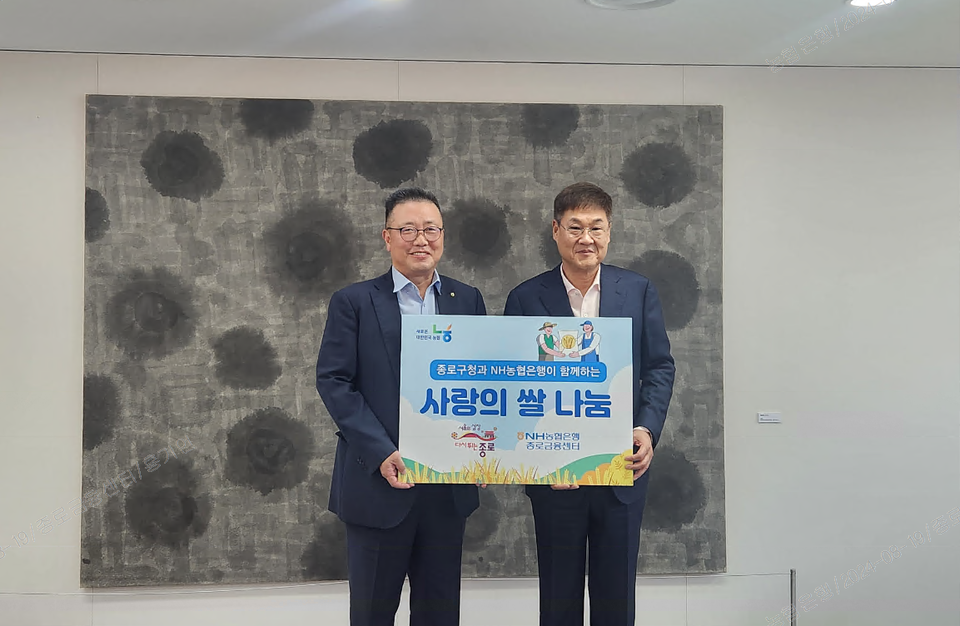 고주영 NH농협은행 종로금융센터장(사진 왼쪽)이 정문헌 종로구청장(사진 오른쪽)에게 쌀을 전달하고 기념 촬영하고 있다. [NH농협은행 제공]