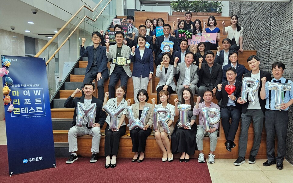 우리은행이 고객 중심 자산관리와 포트폴리오 영업문화 조성을 위해 전 직원이 참여하는 ‘2024 마이 W 리포트 콘테스트’를 개최한다. 콘테스트에 참여한 직원들과 우리은행 송현주 자산관리그룹장(두번째 줄 왼쪽에서 세번째)이 기념사진을 촬영하고 있다. [우리은행 제공]