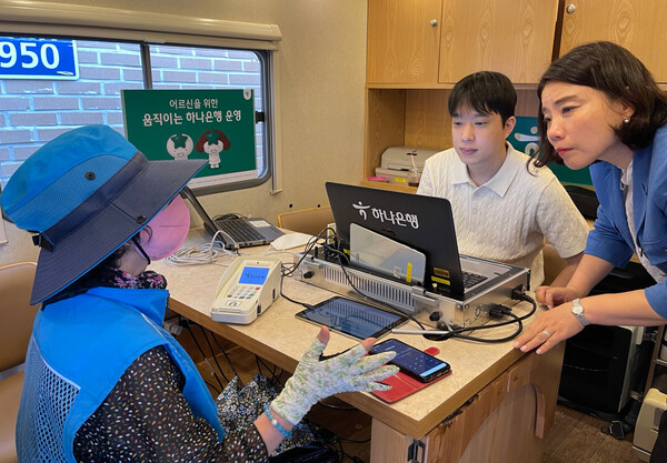 스마트 창구, 포터블 단말기, 카드 즉발기 등이 탑재된 이동점포 '어르신을 위한 움직이는 하나은행'에서 하나은행 직원이 어르신과 상담을 진행하고 있다. [하나은행 제공]