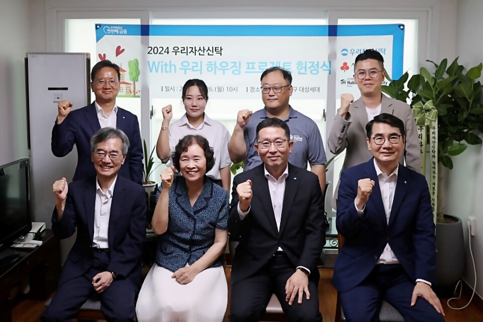 이광회 한국해비타트 사무총장(앞줄 왼쪽 첫번째), 이종근 우리자산신탁 대표(앞줄 왼쪽 세번째) 등 양사 임직원이 참여한 가운데 주거환경 개선사업으로 진행된 노후주택 수리 완공을 기념하여 헌정식 행사를 진행했다. [우리금융 제공]