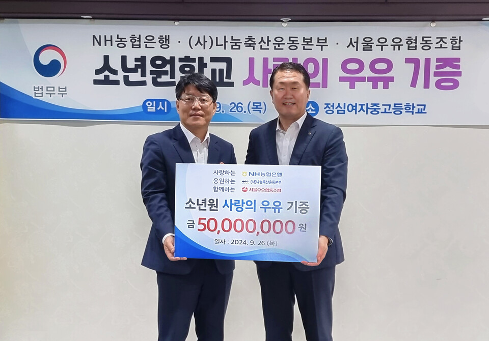 지난 26일 정심여자중고등학교에서 열린 사랑의 우유나눔 행사에서 법무부 이영면 범죄예방정책국장(왼쪽)과 농협은행 김문기 부행장(오른쪽)가 기념촬영을 하고 있다. [NH농협은행 제공]