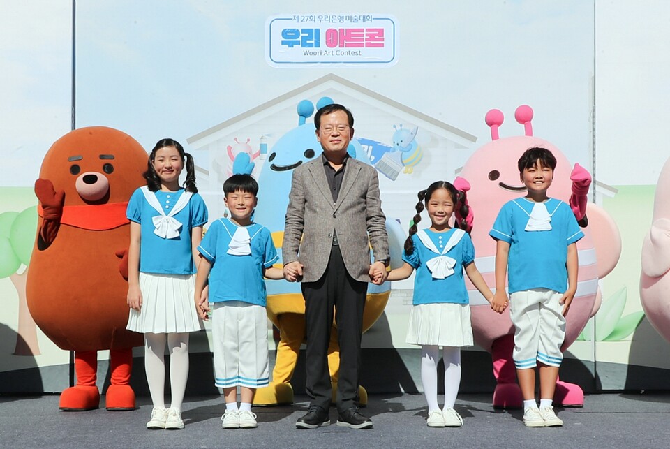 조병규 우리은행 은행장이 지난 29일 마포 문화비축기지에서 열린 제27회 우리은행 우리미술대회 '우리아트콘'의 축하공연을 진행한 다문화어린이합창단 단원들과 기념사진을 촬영하고 있다. [우리은행 제공]