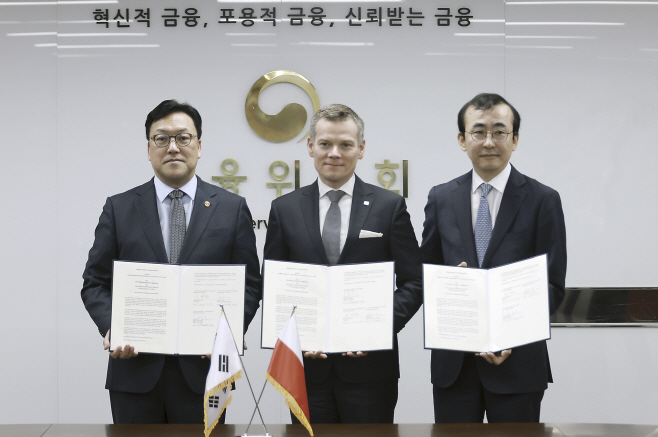 김병환 금융위원장(왼쪽)이 13일 오전 서울 중구 정부서울청사에서 야첵 야스트로제브스키 폴란드 금융감독청 청장(가운데), 이세훈 금융감독원 수석부원장(오른쪽)과 업무 협약을 체결하고 기념촬영을 하고 있다. [금융위원회 제공]