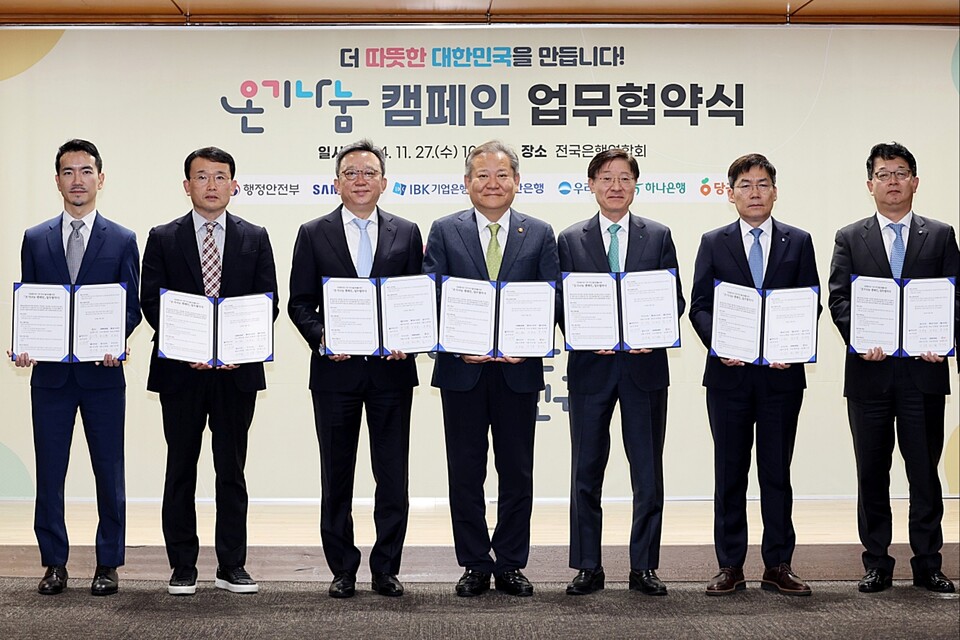 27일 '온기나눔 캠페' 협약식에서 이상민 행정안전부 장관(가운데)과 우리은행 IT그룹 조한래 부행장(맨 오른쪽)이 관계자들과 기념촬영을 하고 있다. [우리은행 제공]