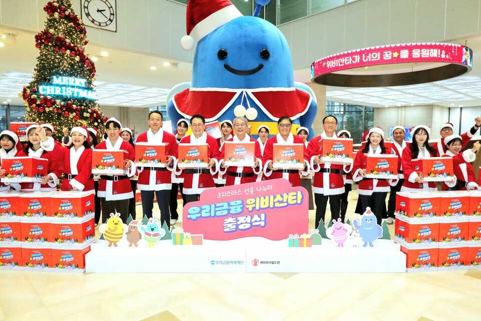 임종룡 우리금융그룹 회장(오른쪽에서 여섯번째), 정태영 세이브더칠드런 총장(오른쪽에서 다섯번째)과 우리금융그룹 임직원이 위비산타 출정식 구호를 외치고 있다. [우리금융그룹 제공]