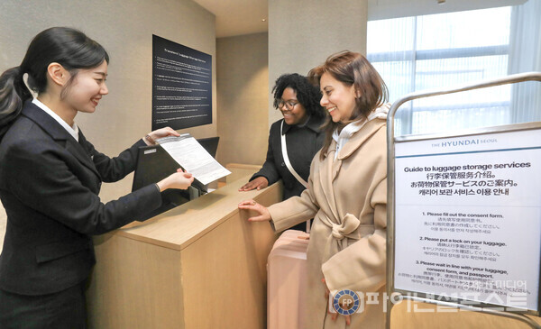 더현대 서울을 방문한 외국인들이 1층에 마련된 투어리스트 데스크에서 캐리어 보관 서비스를 안내받고 있는 모습. [현대백화점그룹 제공]