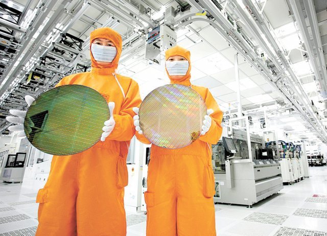 SK하이닉스 메모리반도체 생산공장 내부 클린룸에서 직원들이 웨이퍼를 들고 있다. [SK하이닉스 제공]