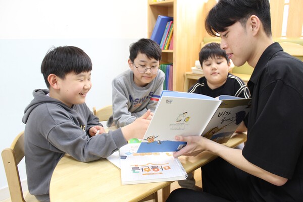 대학생 멘토 '글샘'이 '안산시다함께돌봄센터 선부가치키움터'에서 다문화가정 아이들에게 동화책을 읽어주고 있다. [사진=현대해상]