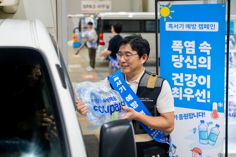 홍용준 CLS대표이사와 위탁배송업체 대표 등이 13일 오후 서울 송파 캠프에서 퀵플렉서들에게 시원한 생수, 이온 음료, 넥쿨러, 쿨토시, 쿨패치, 스포츠캔디 등을 지급하고 있다. [쿠팡 제공]