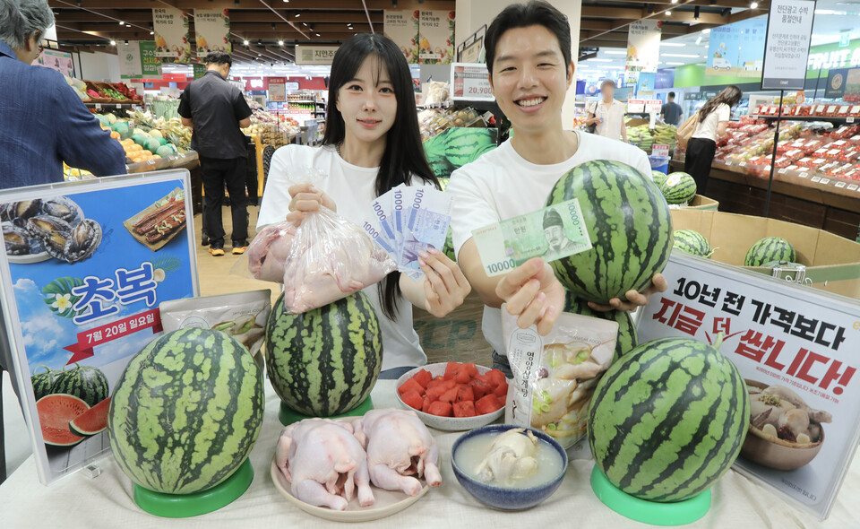 15일 수요일 오전 이마트 용산점에서 모델들이 10년 전보다 더 싼 초복 음식을 소개하고 있다. ]이마트 제공]
