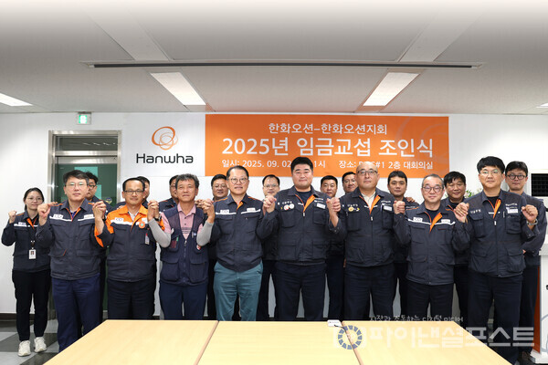 한화오션 김희철 대표이사(앞줄 왼쪽에서 네번째)와 전국금속노조 경남지부 한화오션지회 김유철 지회장(앞줄 왼쪽에서 다섯번째) 등 노사 교섭위원들이 두 손을 잡고 상생을 다짐하고 있다. [한화오션 제공]