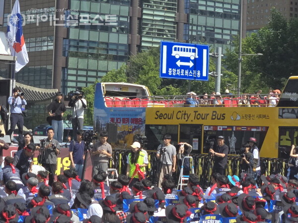 외국인 관광객들이 도로 정체를 유발한 금융노조 시위대에 관심을 보이고 있다. [사진=임혜현 기자]