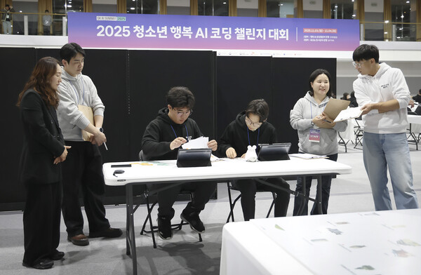 행복AI코딩챌린지의 미션 챌린지에 참가한 청소년팀이 심사위원들 앞에서 AI 로봇에 카드 코딩을 하고 있는 모습 [SK텔레콤 제공]