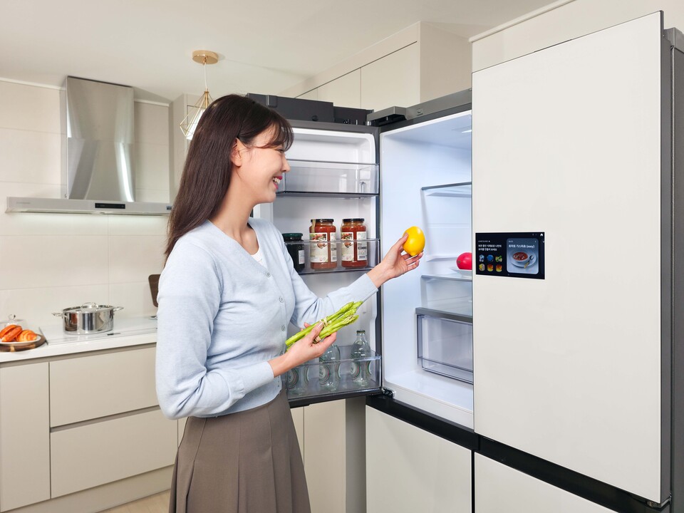 삼성전자 모델이 냉장고에 들어오고 나가는 식재료를 인식해 자동으로 푸드 리스트를 생성하는 'AI 비전 인사이드(AI Vision Inside)'를 체험하고 있다. [삼성전자 제공]