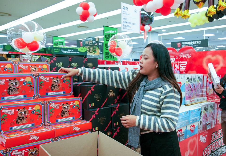 롯데웰푸드 ‘빼빼로 Agent:P(에이전트 피)’ 활동 인원이 마트에 진열된 빼빼로를 배경으로 콘텐츠 촬영을 하고 있다. [롯데웰푸드 제공]
