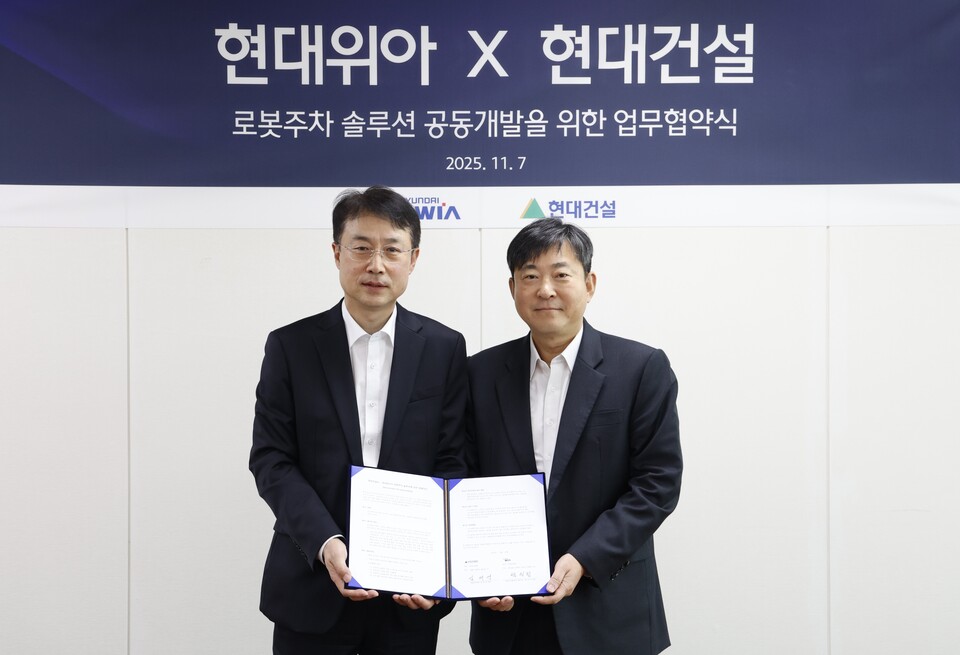 현대건설 기술연구원 김재영 원장(오른쪽)과 현대위아 모빌리티솔루션사업부 백익진 상무가 7일 경기도 의왕시 현대위아 의왕연구소에서 열린 '로봇 친화형 주차솔루션 공동개발을 위한 업무협약식'에서 기념 사진을 찍고 있다. [현대건설 제공]