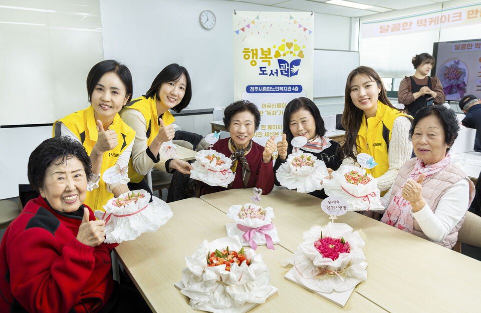 20일 청주시노인종합복지관에서 오비맥주 행복도서관 12호점 개관식을 마치고 기념사진을 찍고 있다. [오비맥주 제공]