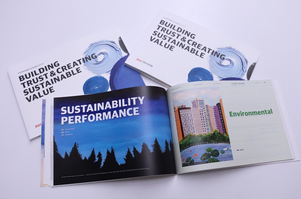 HDC현대산업개발이 한국ESG기준원(KCGS)의 2025년 ESG 평가 및 등급 공표에서 2년 연속 통합 A등급을 획득했다. (장애인 예술단이 직접 그린 그림이 적용된 HDC현대산업개발의 2025 지속가능경영보고서). [HDC현대산업개발 제공]