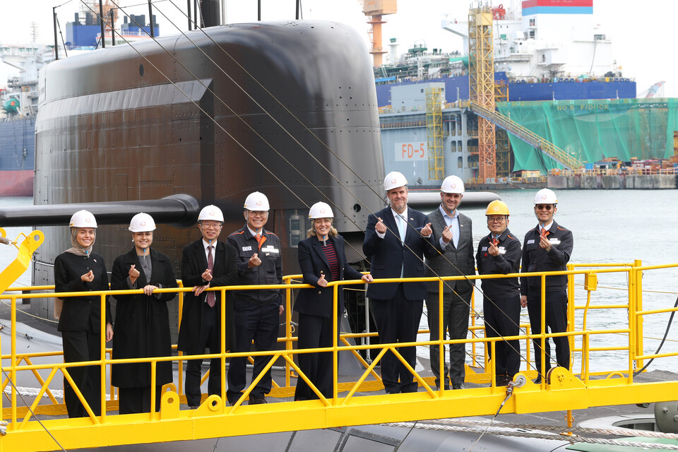 24일 멜라니 졸리 캐나다 산업부 장관(가운데)이 김희철 한화오션 대표이사(왼쪽에서 네 번째), 강환석 방위사업청 차장(왼쪽에서 세 번째) 등과 함께 한화오션이 건조한 잠수함인 장영실함을 배경으로 단체사진을 찍고 있다. [한화오션 제공]