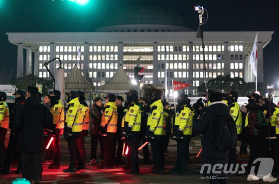 윤석열 대통령의 비상계엄 해제 요구 결의안이 국회 본회의에서 통과된 4일 새벽 서울 여의도 국회 정문 앞에서 경찰 병력들이 경계 근무를 서고 있다. 여야는 이날 본회의에서 재석 190명 중 찬성 190명으로 비상계엄 해제 요구 결의안을 가결 처리했다. 이에 따라 계엄령 선포는 무효가 됐다고 국회의장실은 설명했다. 윤 대통령은 긴급 대국민 특별담화를 통해 "바로 국무회의를 통해 국회의 요구를 수용해 계엄을 해제할 것"이라며 "다만 즉시 국무회의를 소집했지만 새벽인 관계로 아직 의결 정족수가 충족되지 못해서 오는 대로 바로 계엄을 해제하겠다"고 했다.